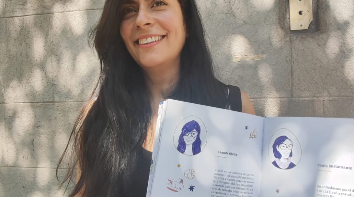 Una mujer de pelo largo sostiene un libro abierto. Es la autora de Refugio, libro ilustrado de poemas